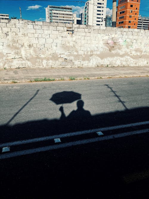 Shadow on the Street of a Man with an Umbrella