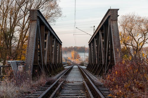 Railway Tracks Stretching through a Steel Bridge in Autumn