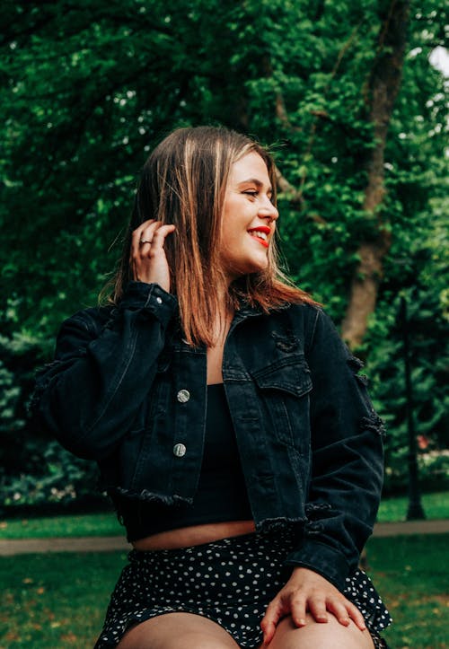 Young Woman in a Casual Outfit Sitting in a Park