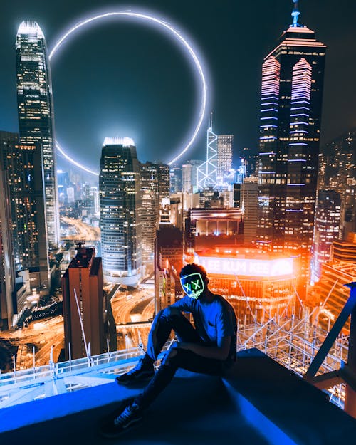 Free Man Sitting On Top Of Building Stock Photo