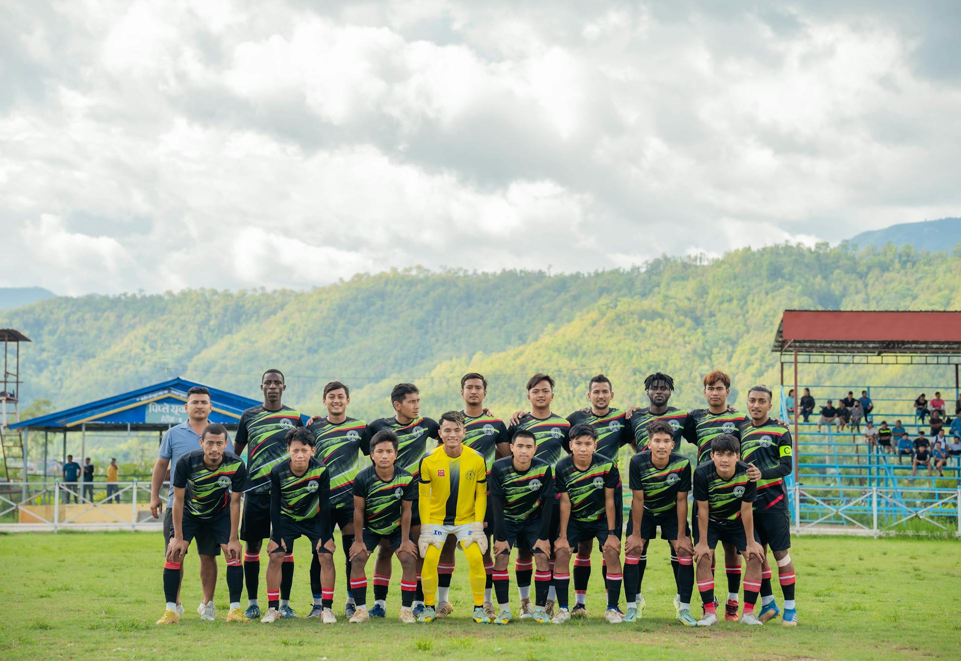 A local football team posing on the field during a sunny day game.