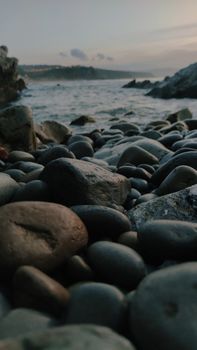 Peaceful stones on a Spanish shoreline at dusk, capturing nature's calm beauty.