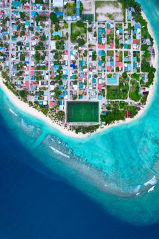 Stunning aerial shot of Meedhoo, Raa Atoll in Maldives showcasing turquoise waters and urban layout.
