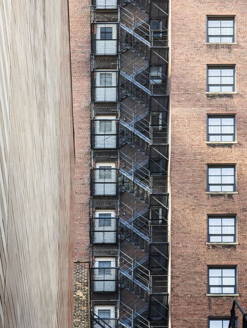 Free Vertical shot of a fire escape on a brick building facade in Chicago, capturing urban architecture. Stock Photo