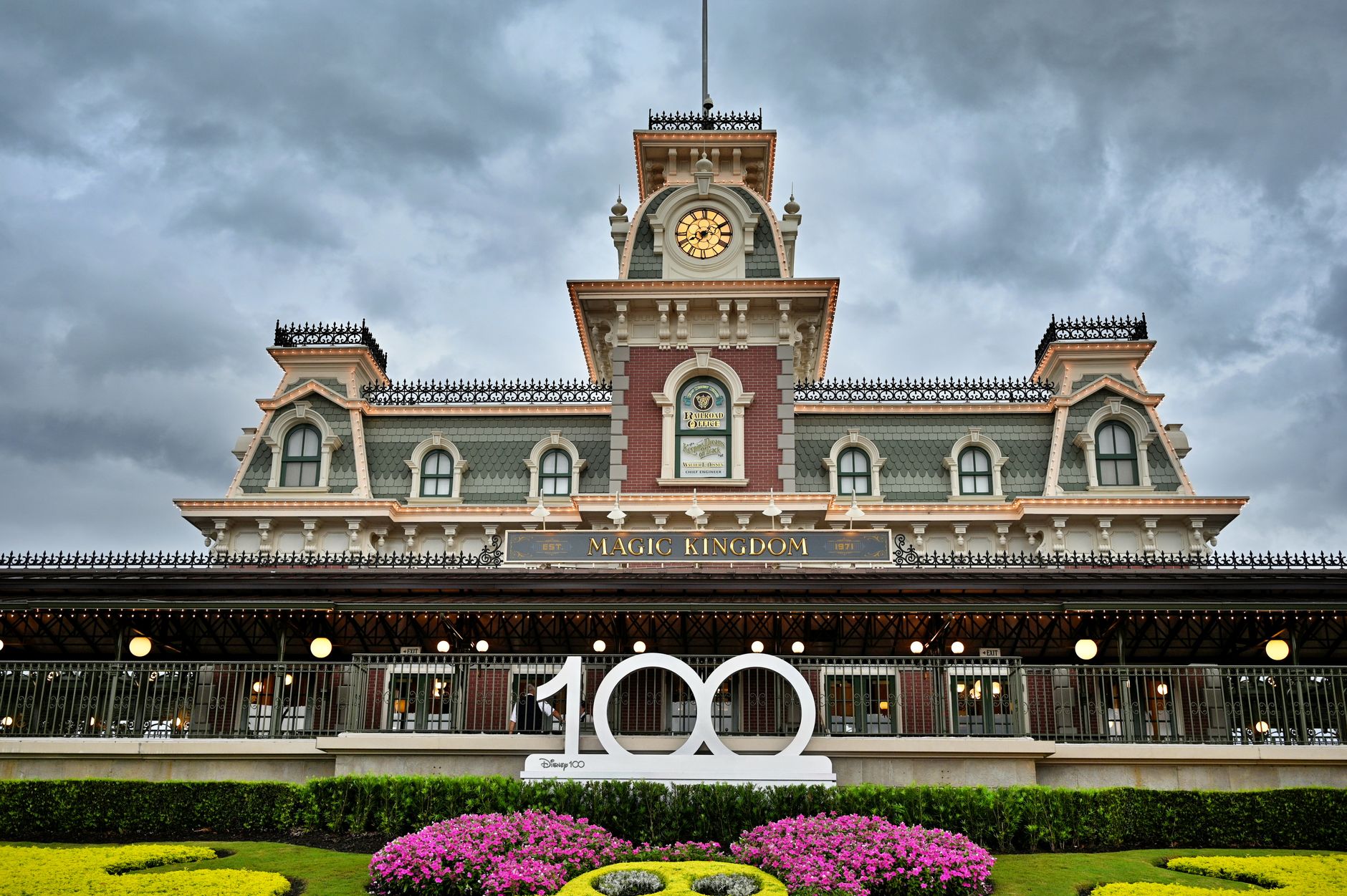 Magic Kingdom entrance under overcast skies in Orlando, showcasing iconic architecture and floral display.