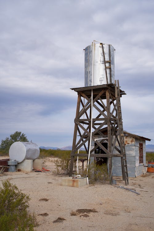 A water tower in the desert with a metal roof