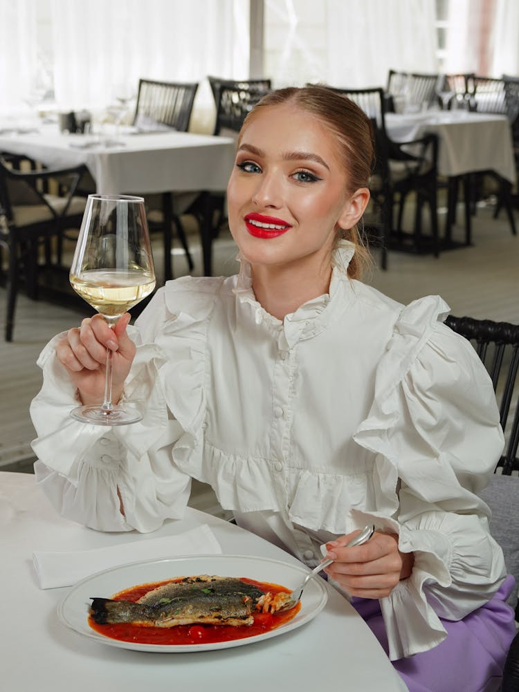 Woman Eating Fish In Restaurant