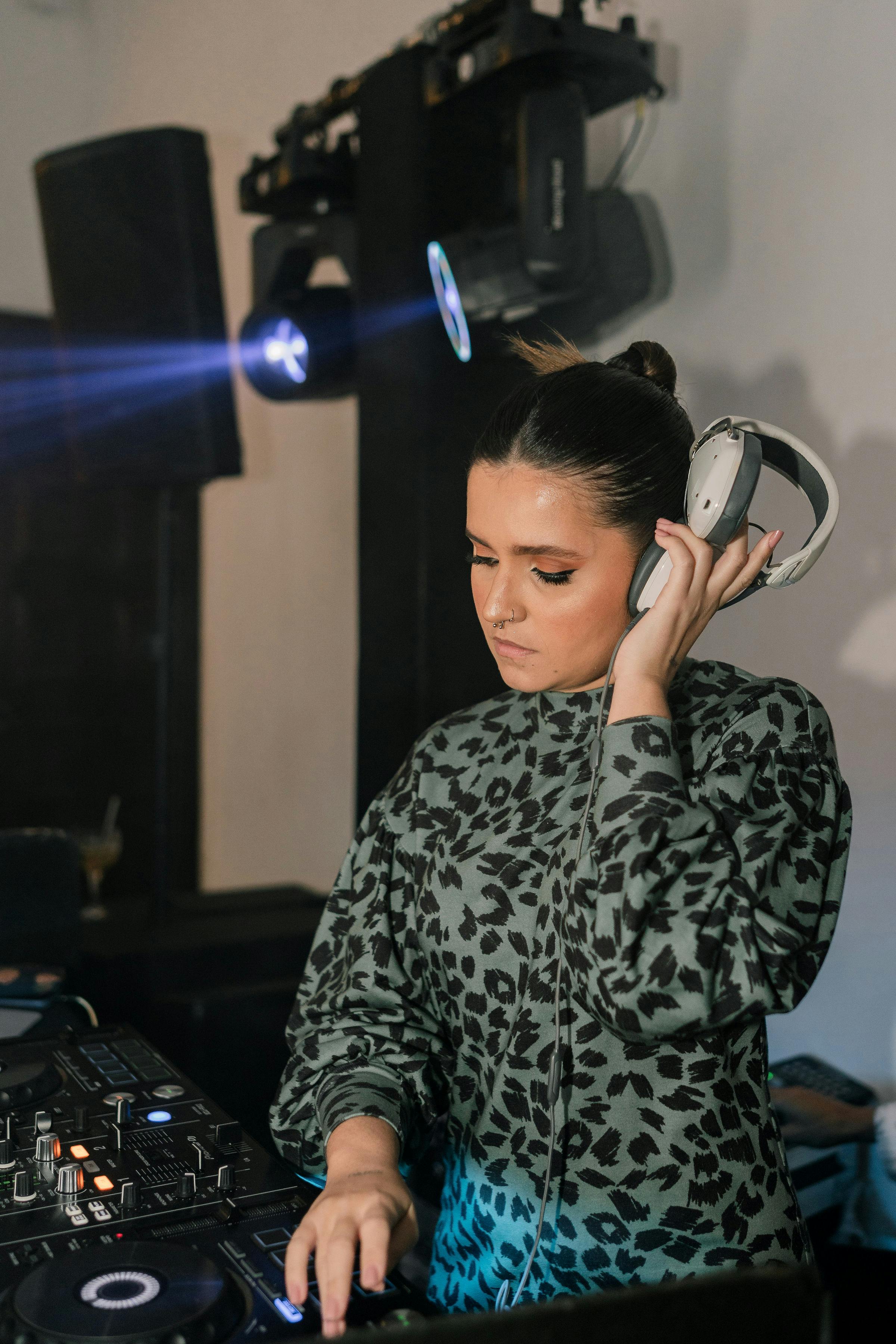 DJ at her Decks, With Headphones in Left Hand · Free Stock Photo