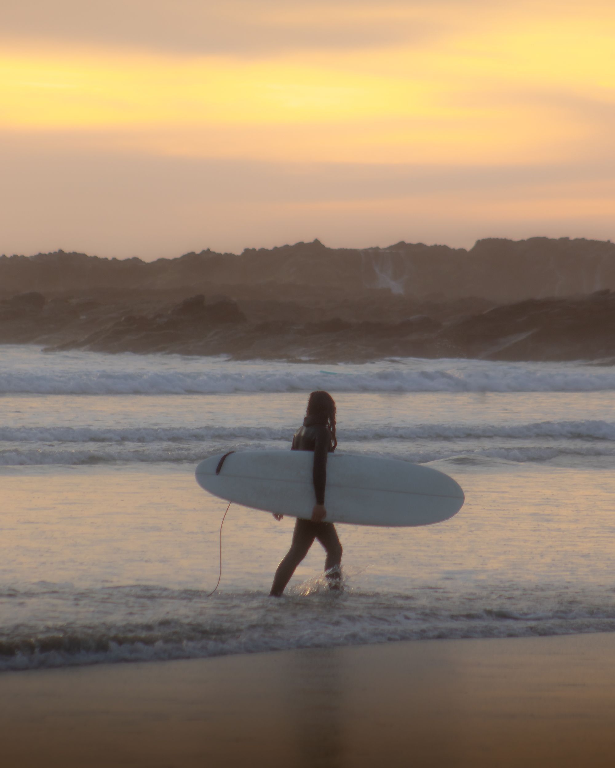 Surfer Carries Surfboard under Arms · Free Stock Photo