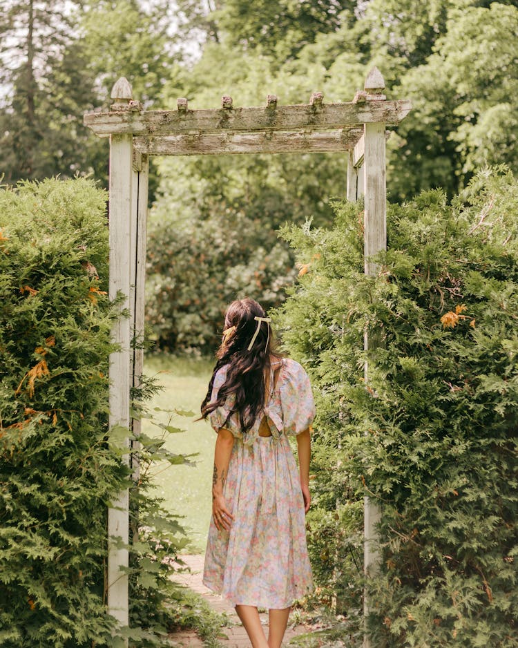 Young Woman In A Dress Walking In The Garden 