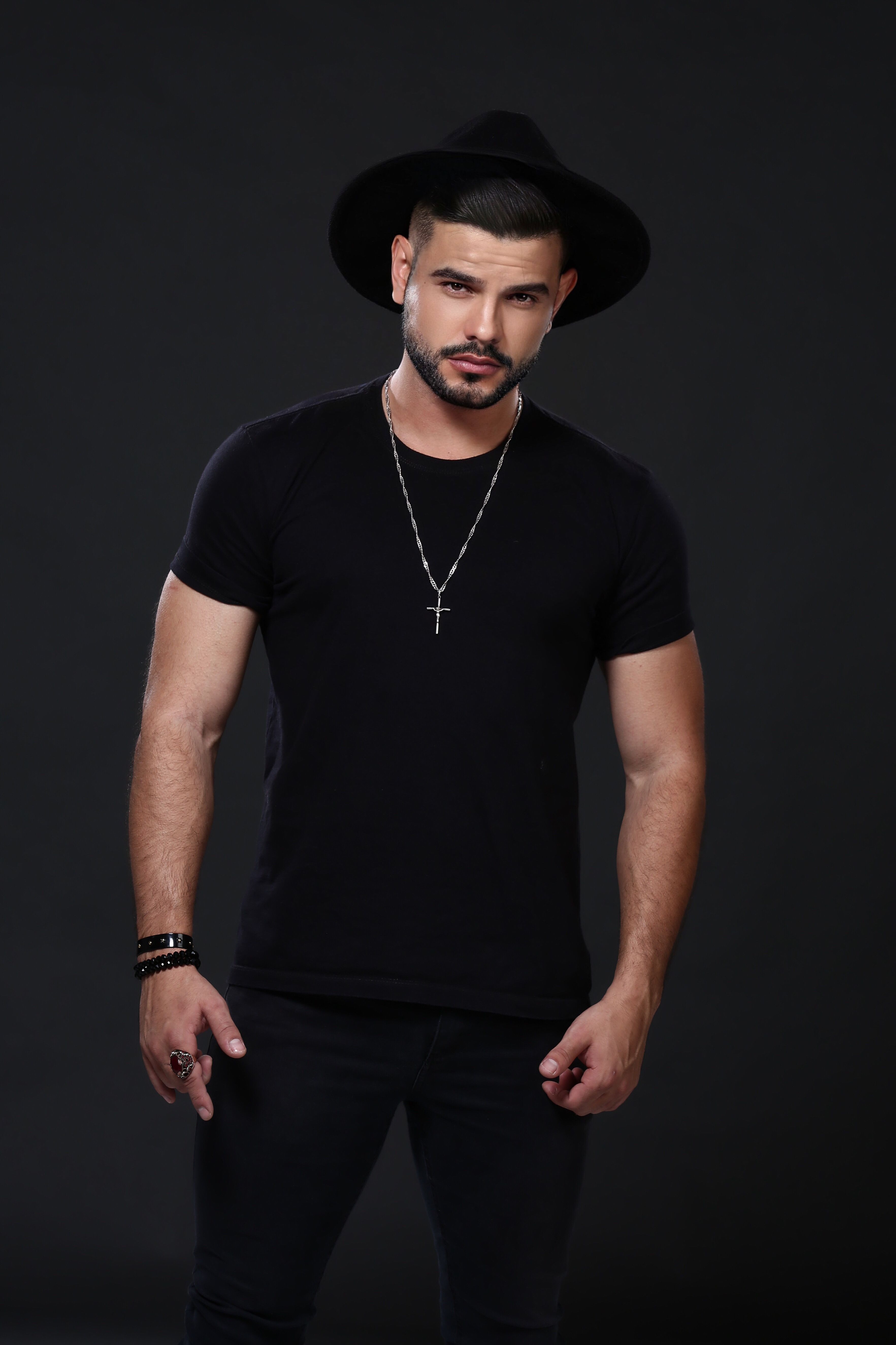 Man in black outfit and hat posing with jewelry and modern style, Brasília