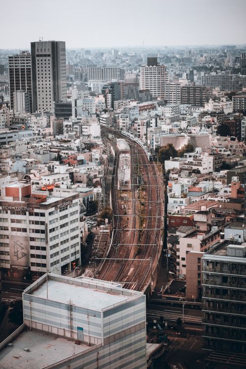 Free A breathtaking aerial view of Tokyo, highlighting its dense cityscape with railway tracks. Stock Photo