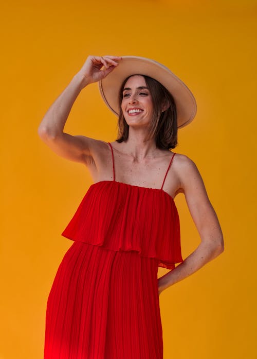 Smiling Young Woman in Hat Posing in Studio