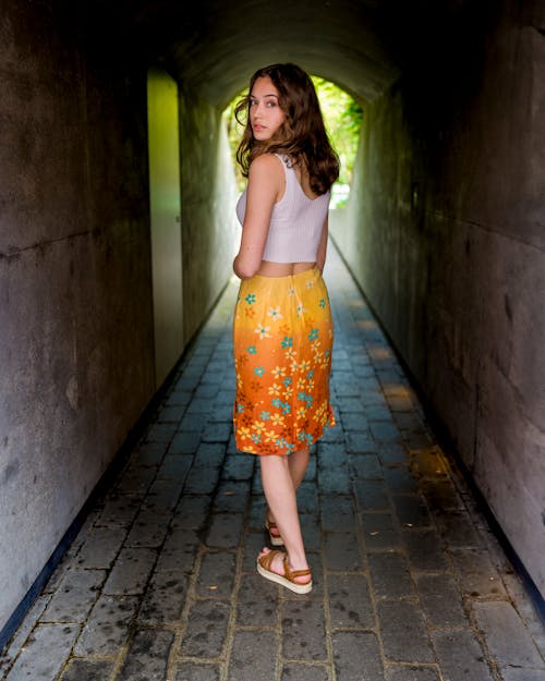 Woman in Skirt Standing in Tunnel