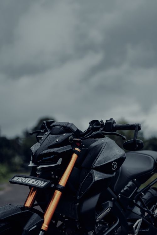 Free A modern motorcycle with a sleek design captured under a cloudy sky, highlighting its power and elegance. Stock Photo