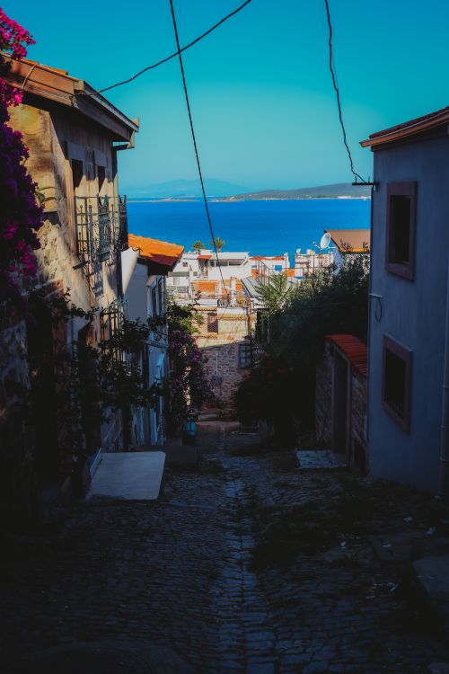 Free Charming narrow street in Ayvalık, Türkiye, showcasing coastal views and traditional architecture. Stock Photo