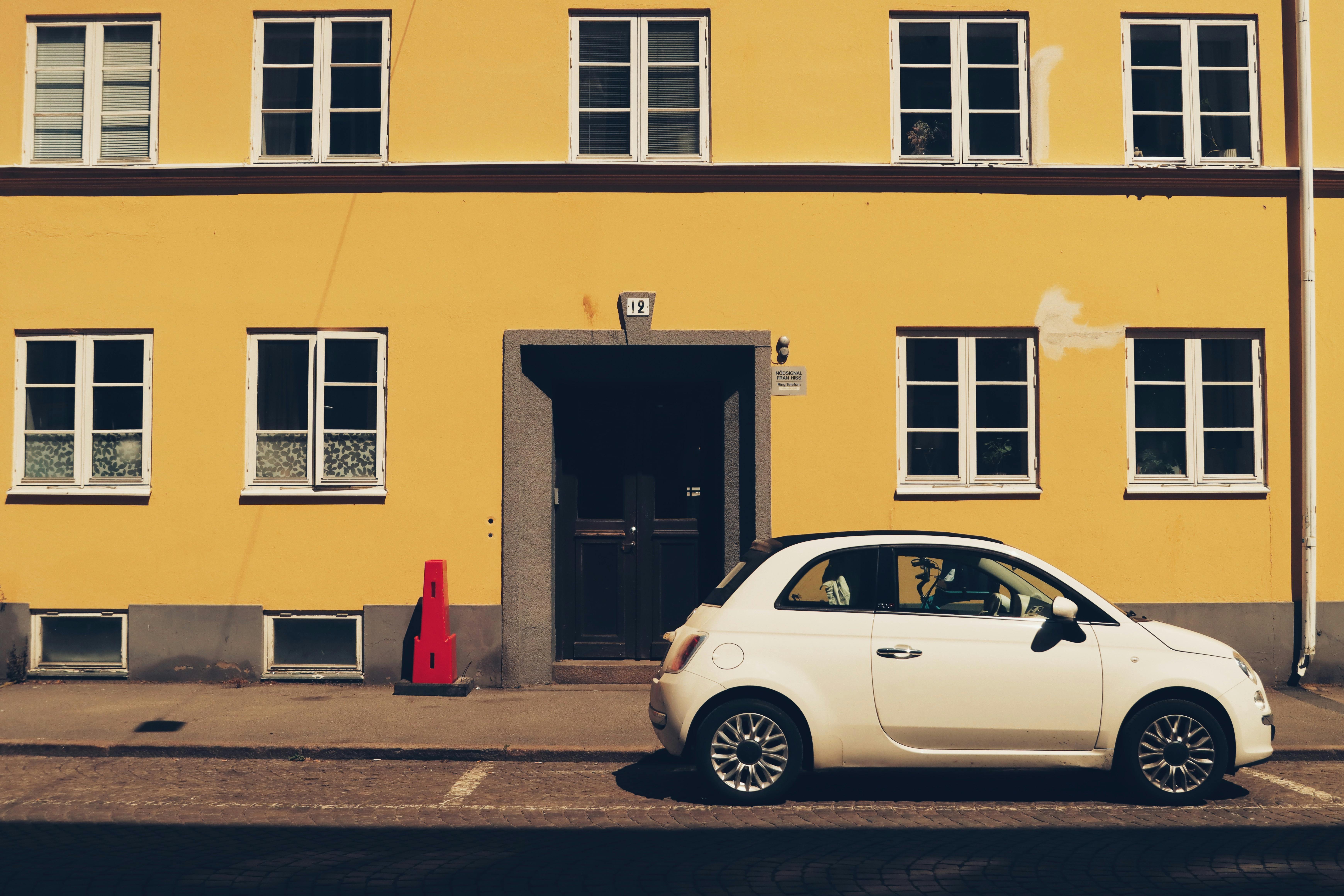 White Fiat parked in front of a yellow building on J&ouml;nk&ouml;ping street, Sweden.