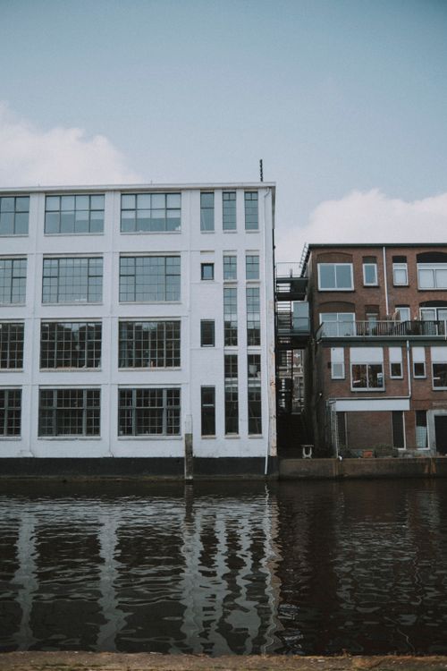 Free Industrial and residential buildings reflected in water along a city canal. Stock Photo