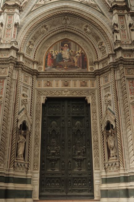 Intricate facade of the Florence Cathedral showcasing Gothic architecture with detailed sculptures and artwork.