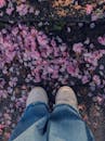Pink Petals Lying Down under Shoes of Standing Person