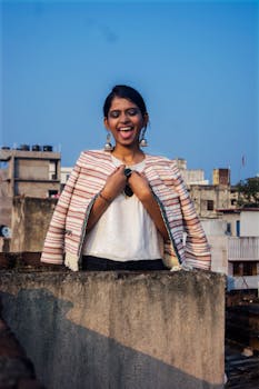 穿着条纹开衫的女人在屋顶上享受阳光明媚的一天