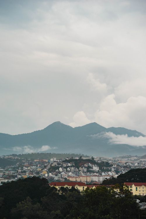 Free A foggy view of Dalat city nestled among mountains, showcasing urban and natural beauty. Stock Photo
