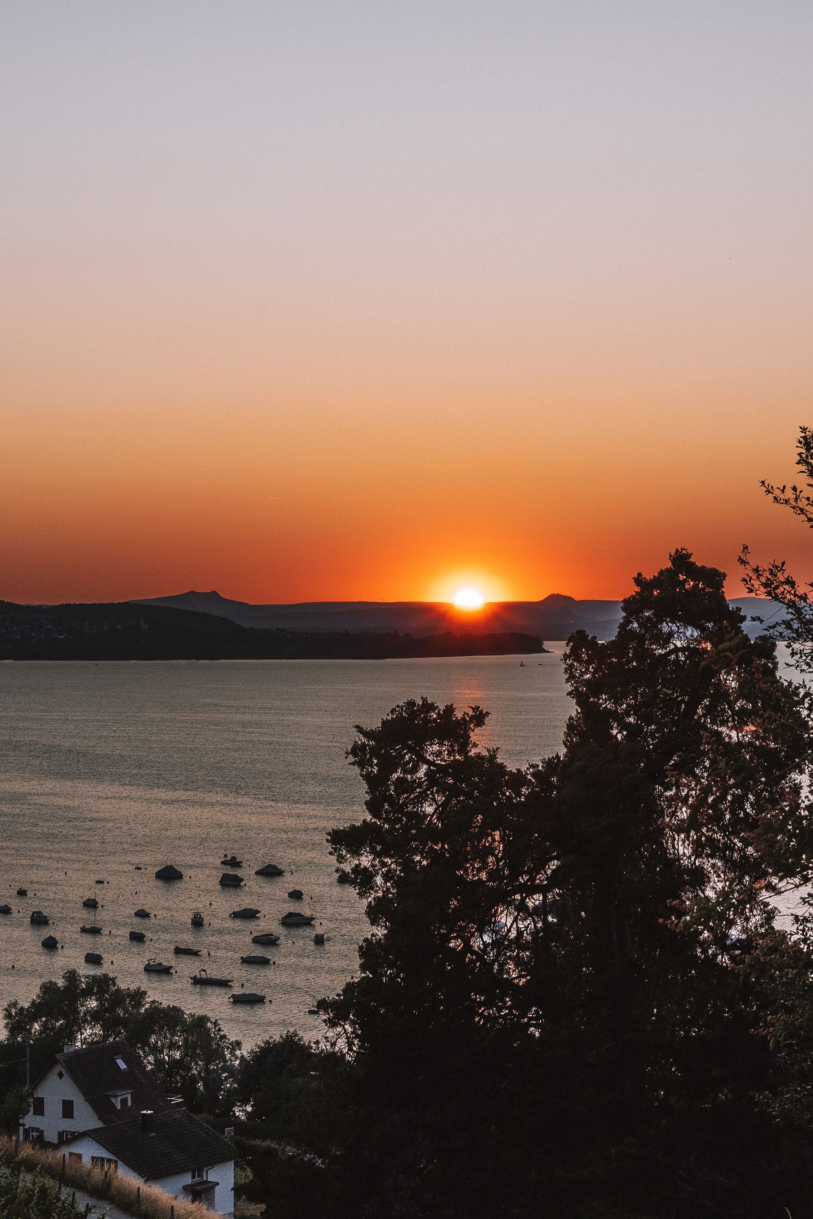 Sunset above the Hills and a Body of Water · Free Stock Photo