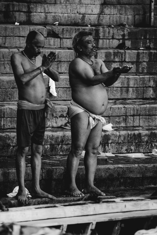 Free Two men perform a Hindu ritual ceremony on steps, captured in black and white. Stock Photo