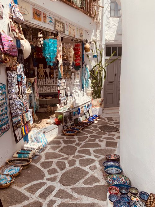 Free Explore a quaint European alley with a vibrant souvenir shop displaying handmade goods and colorful pottery. Stock Photo