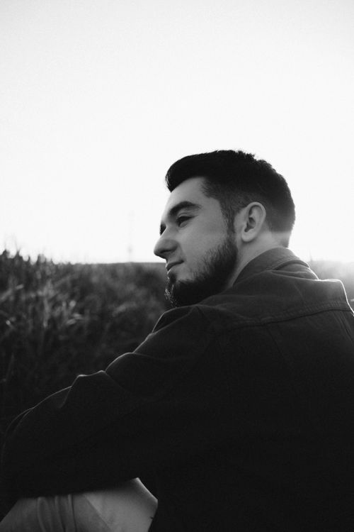 Free Black and white portrait of a man outdoors, capturing a serene moment in nature. Stock Photo