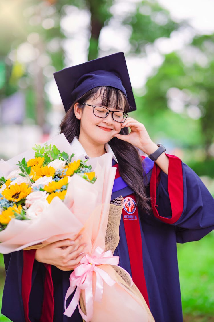 Smiling Graduate Student Holding A Bouquet