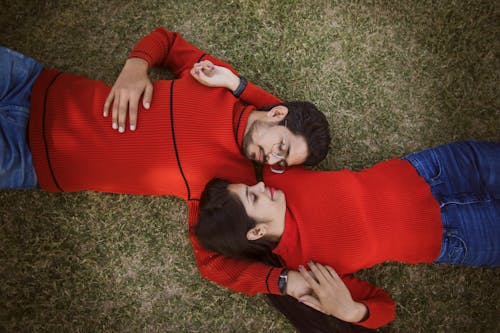 Couple Lying Down Together in Red Sweaters