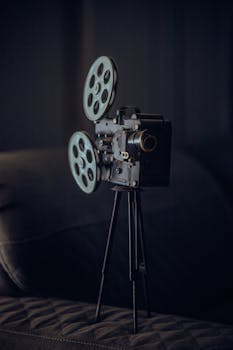Close-up of an antique film projector on a tripod stand, evoking a classic cinematic era.