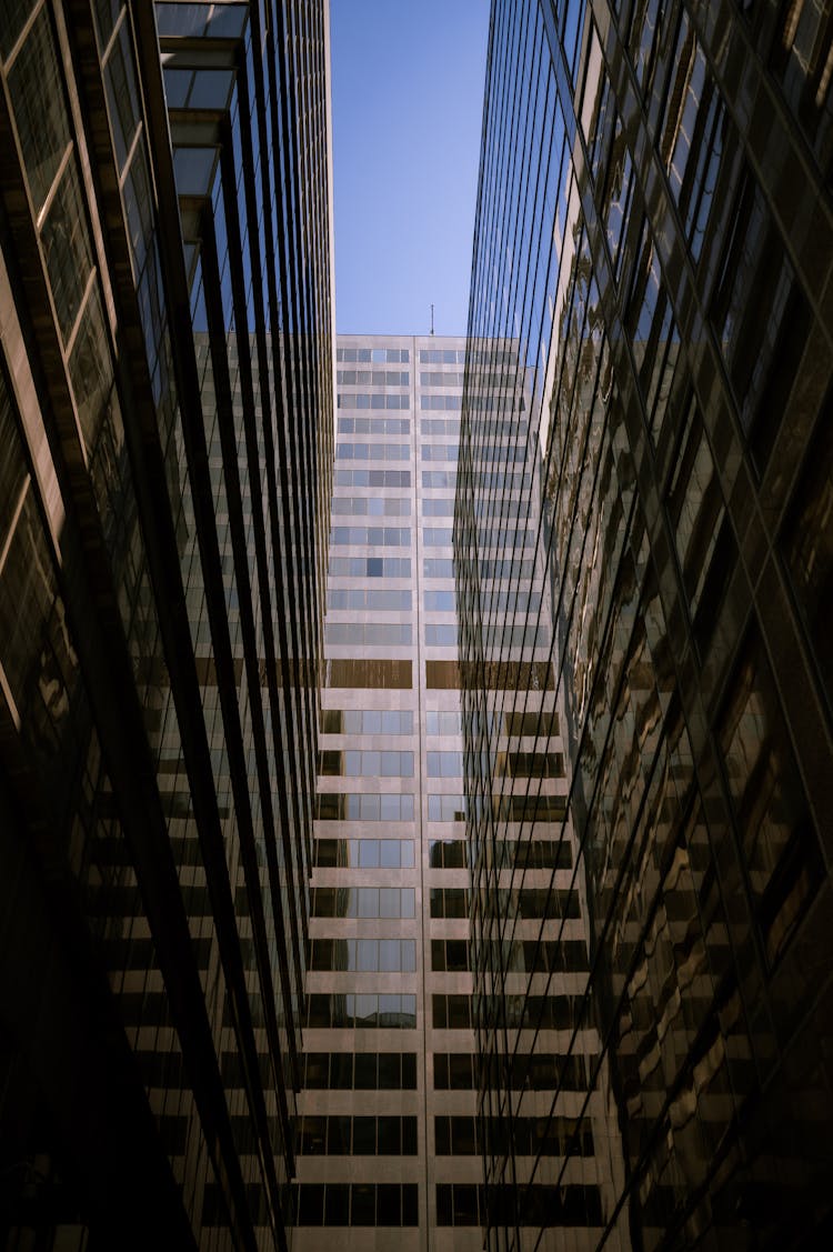 Blue Sky Seen Through Narrow Passage Between Reflecting Glass Buildings