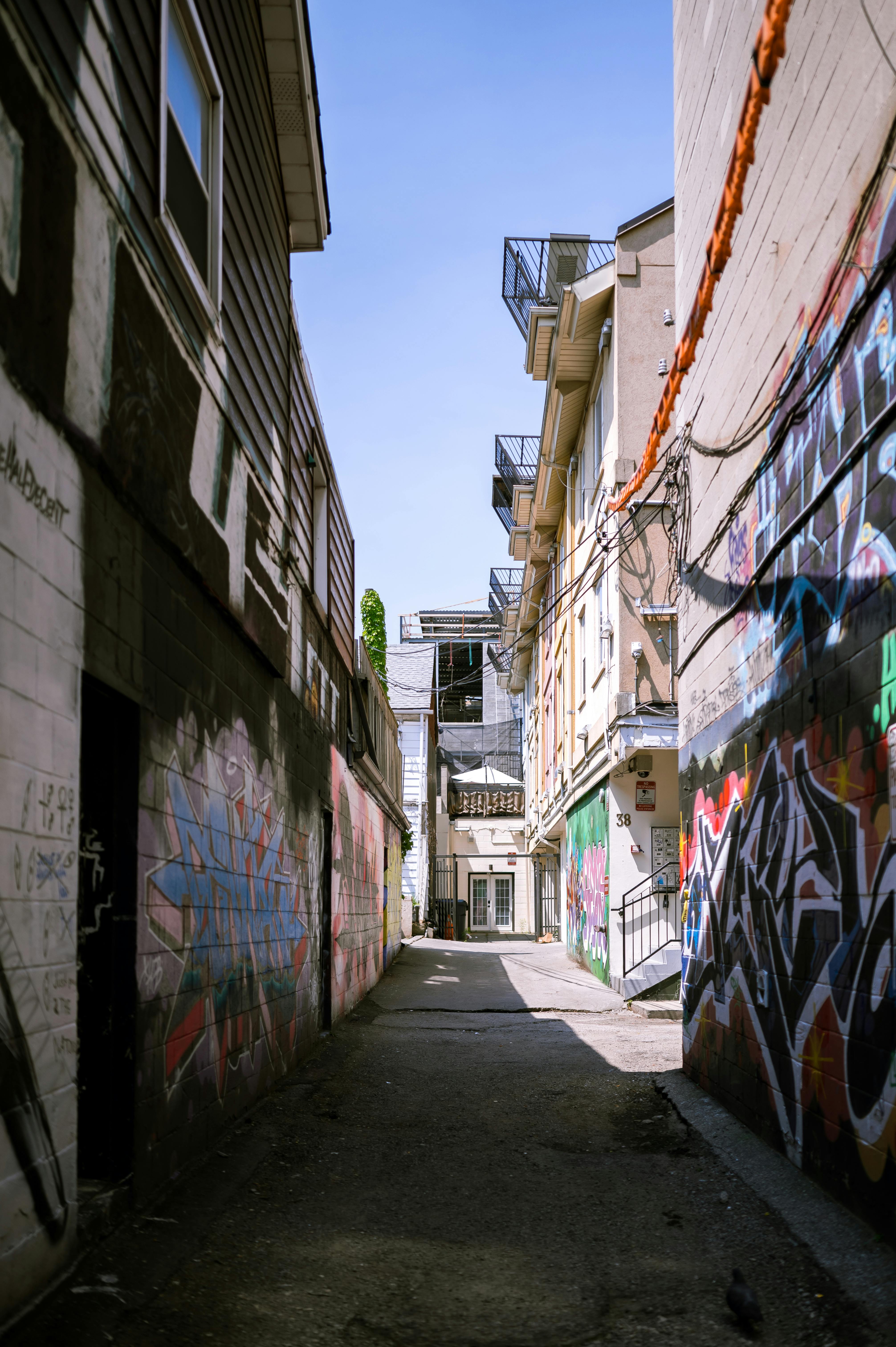 Buildings along Narrow Back Alley Covered in Graffiti · Free Stock Photo