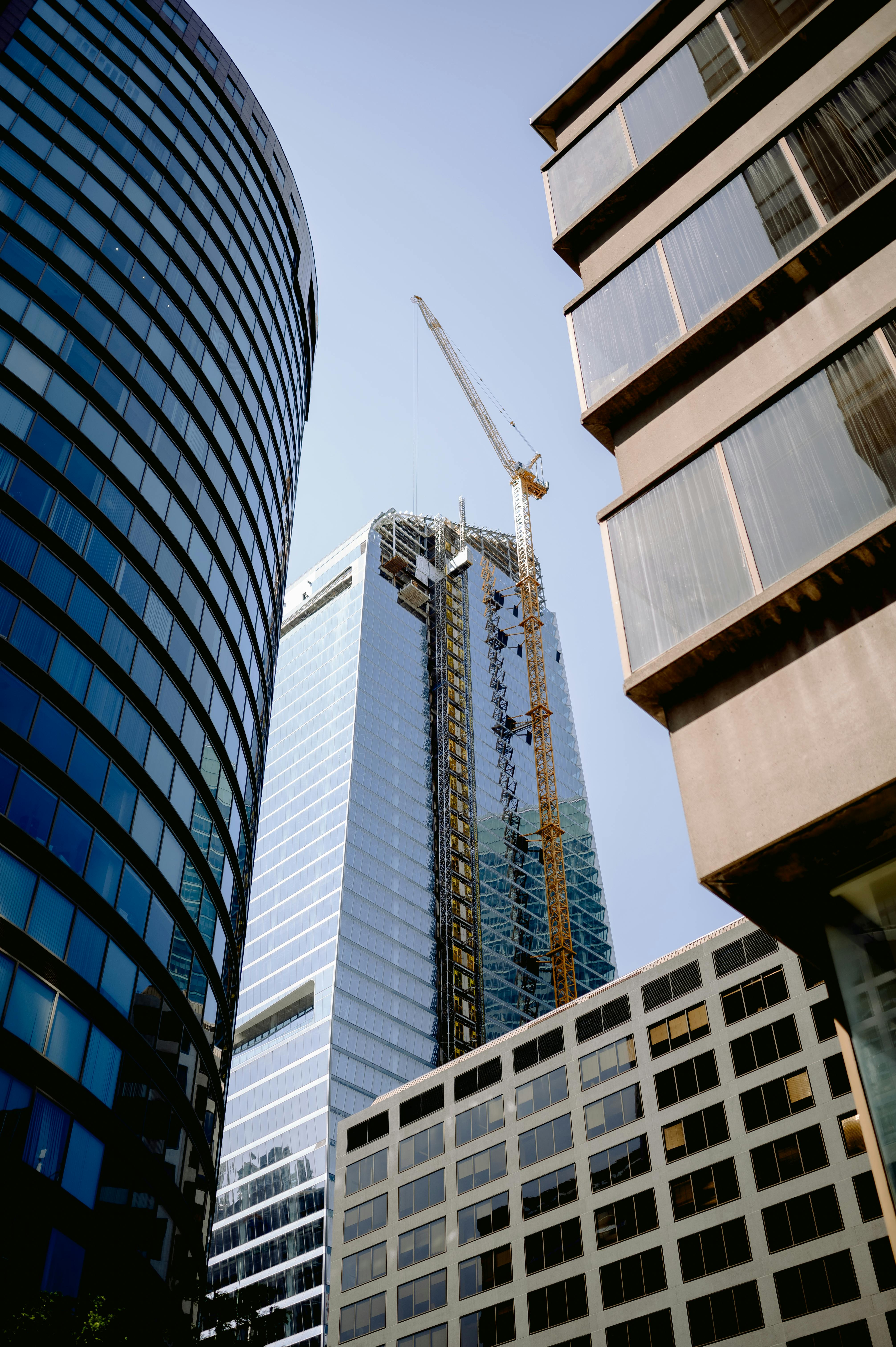 View of modern skyscrapers with a construction crane in an urban cityscape.