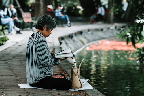 讀一本書時坐著的女人的照片