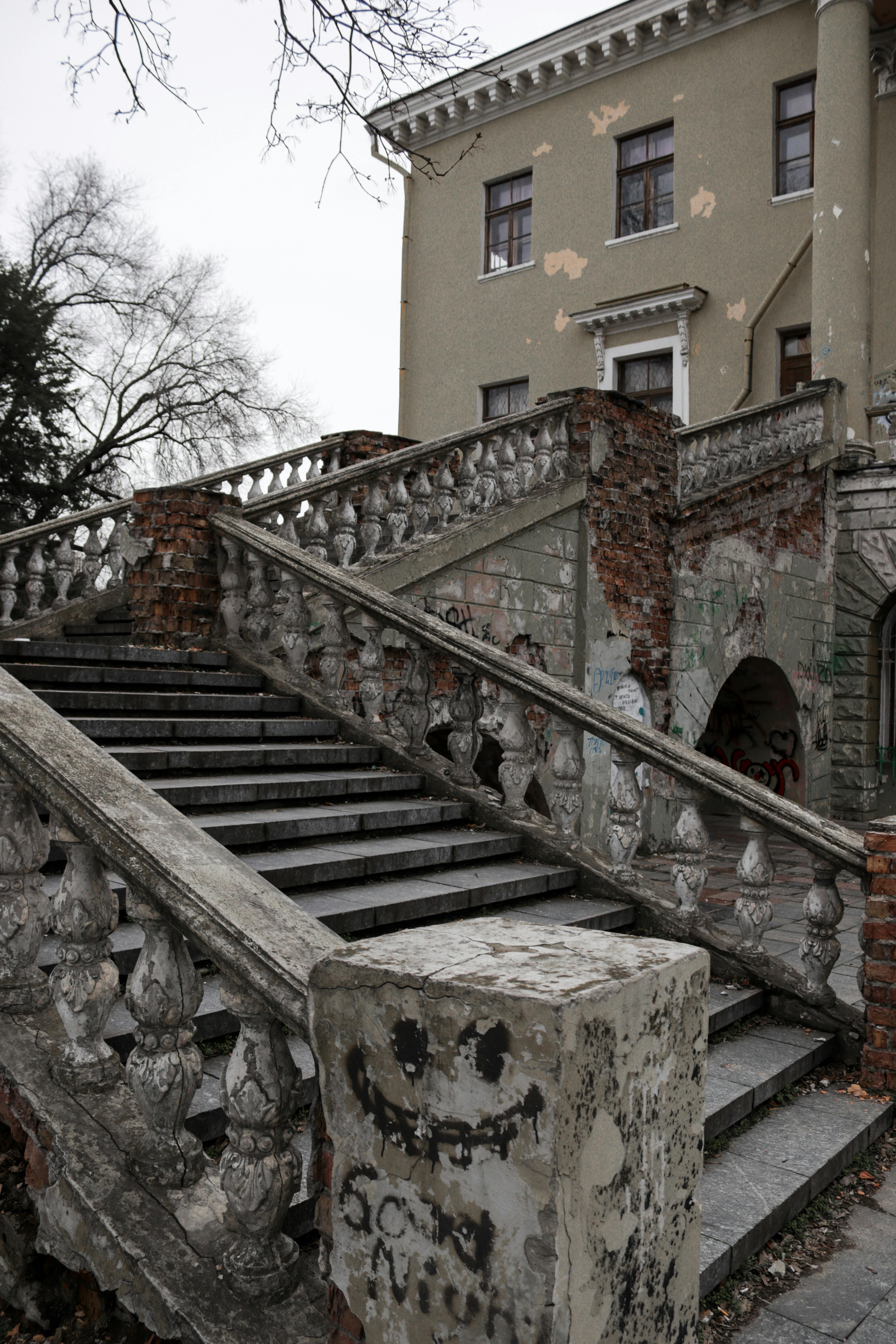 An old brick building with weathered stairs, showcasing urban decay and architectural history.