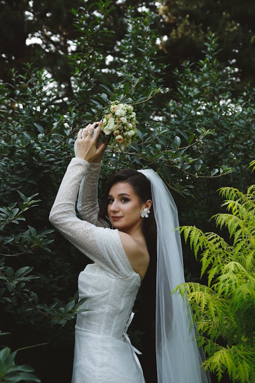 Bride Holding a Bouquet and Posing Outside 
