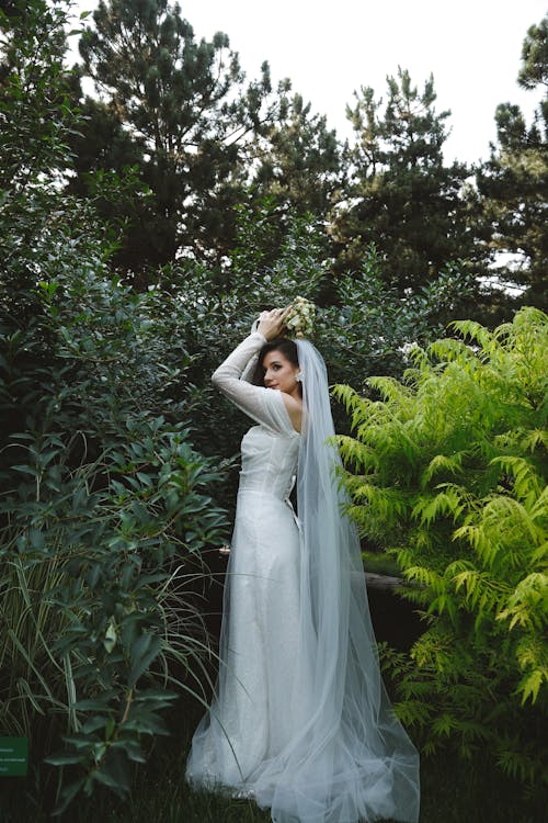 Bride with a Long Veil Posing in the Garden 