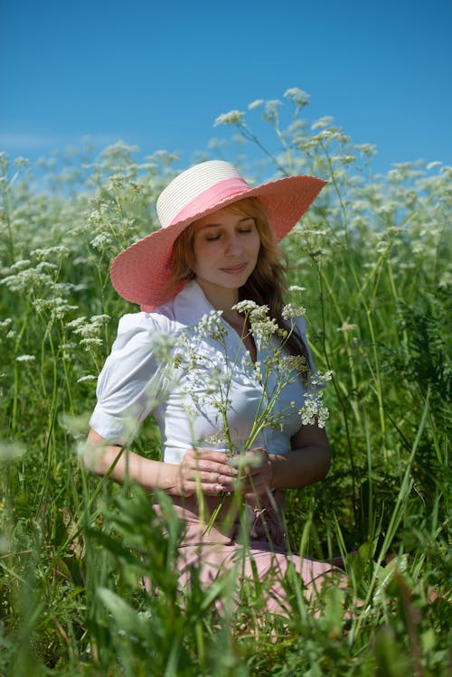 Young Woman Standing on a Field in Summer 