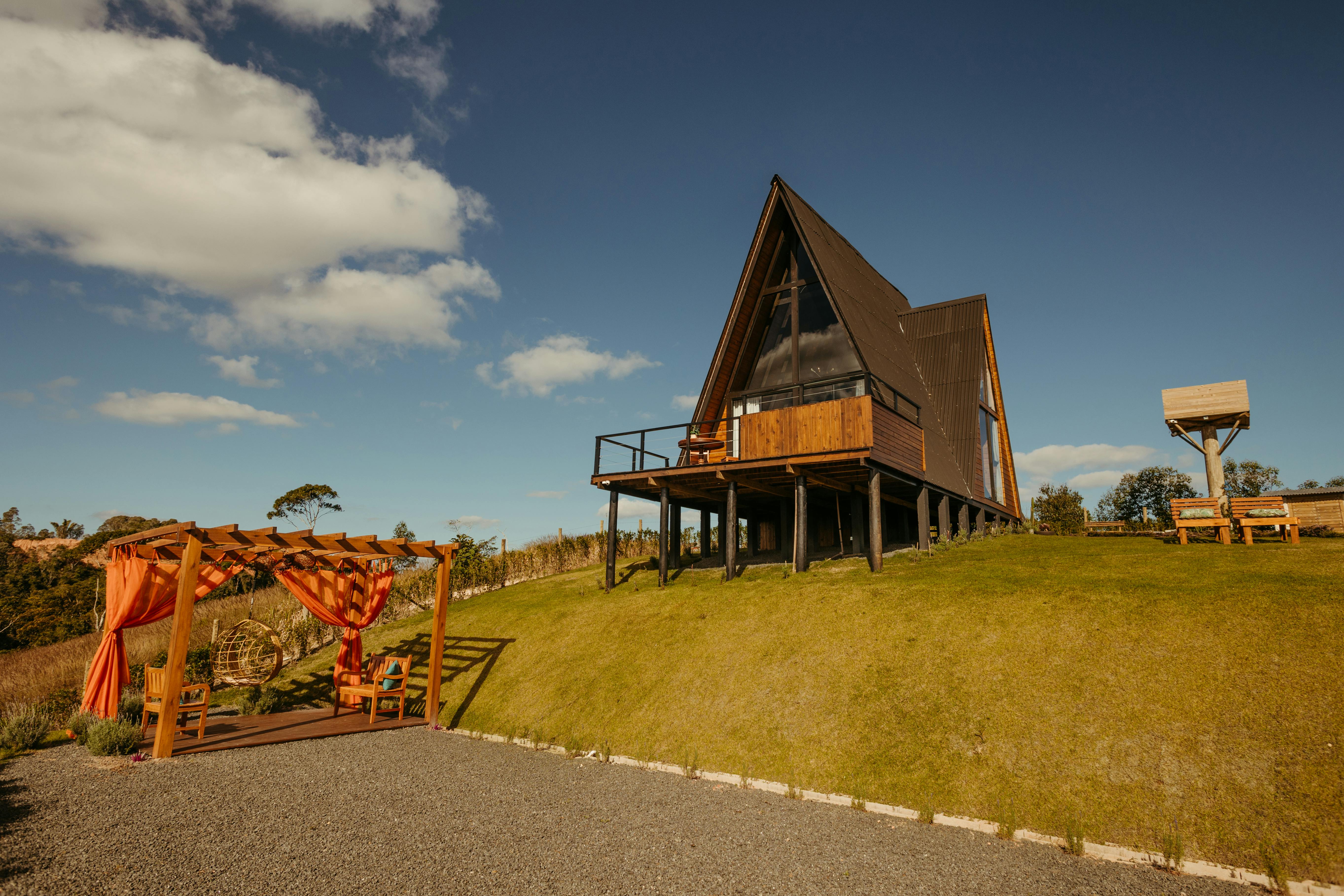 Charming A-frame cabin with wooden terrace in Santa Teresa, perfect for summer glamping and leisure.