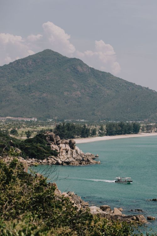 Free A tranquil view of the Phan Rang coastline with a mountain backdrop and clear turquoise sea. Stock Photo