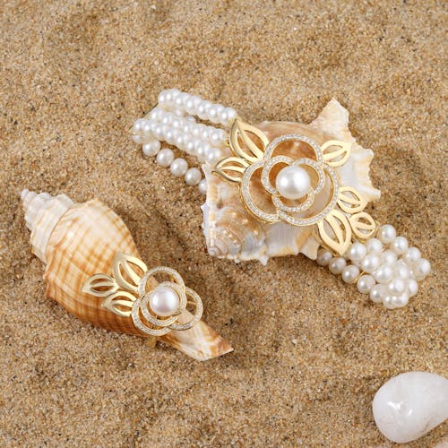 Gold Ring with Pearl and Pearl Bracelet with Gold Flower on the Beach