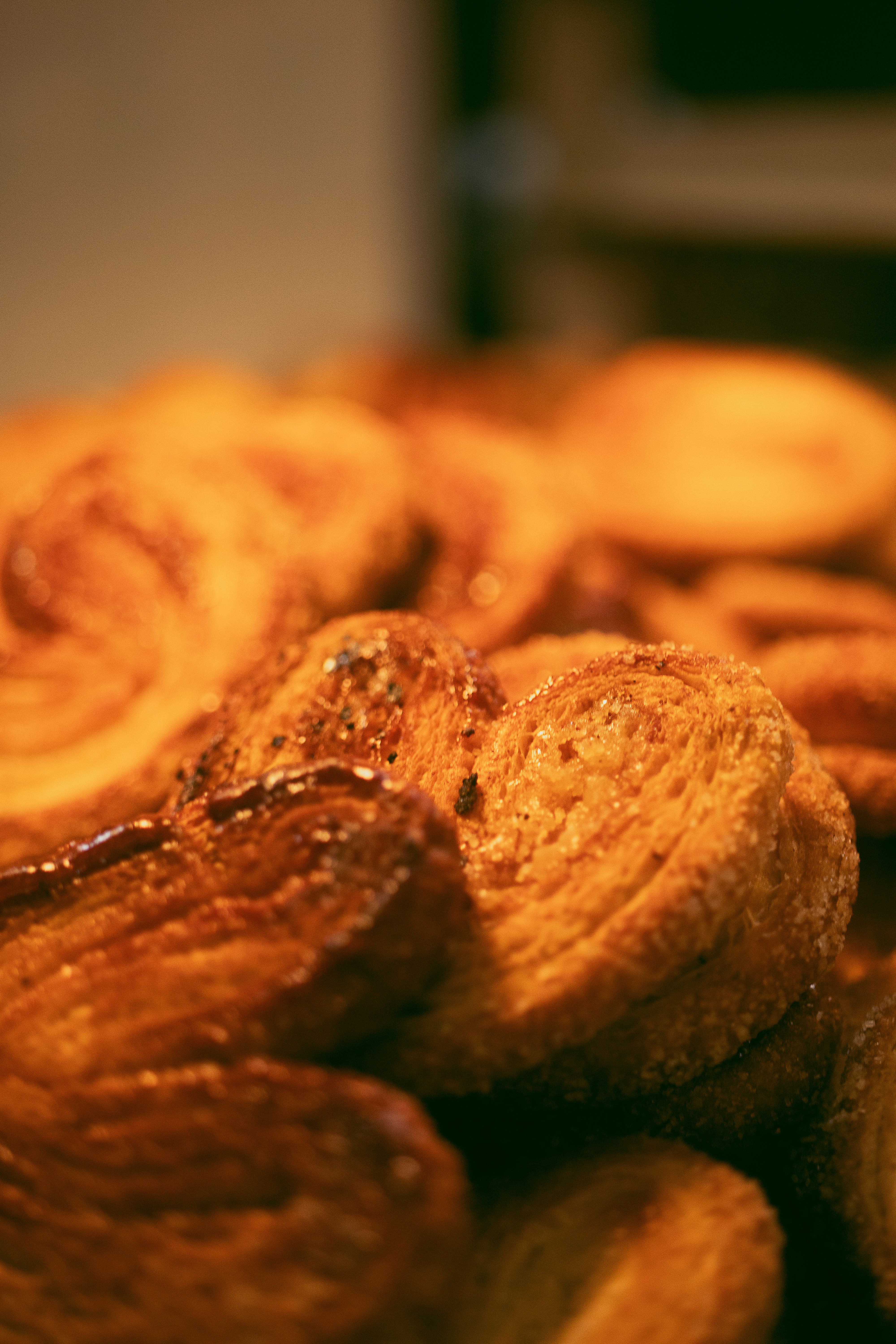 Fotomural Primer plano de pastas palmier recién horneadas, mostrando sus capas de mantequilla y dulzura caramelizada.