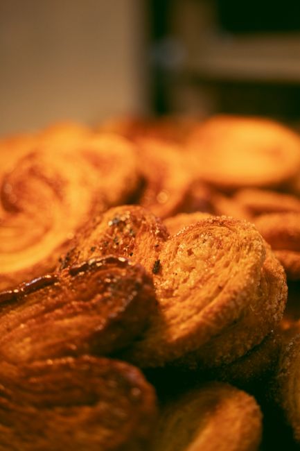 Fotomural Primer plano de pastas palmier recién horneadas, mostrando sus capas de mantequilla y dulzura caramelizada.