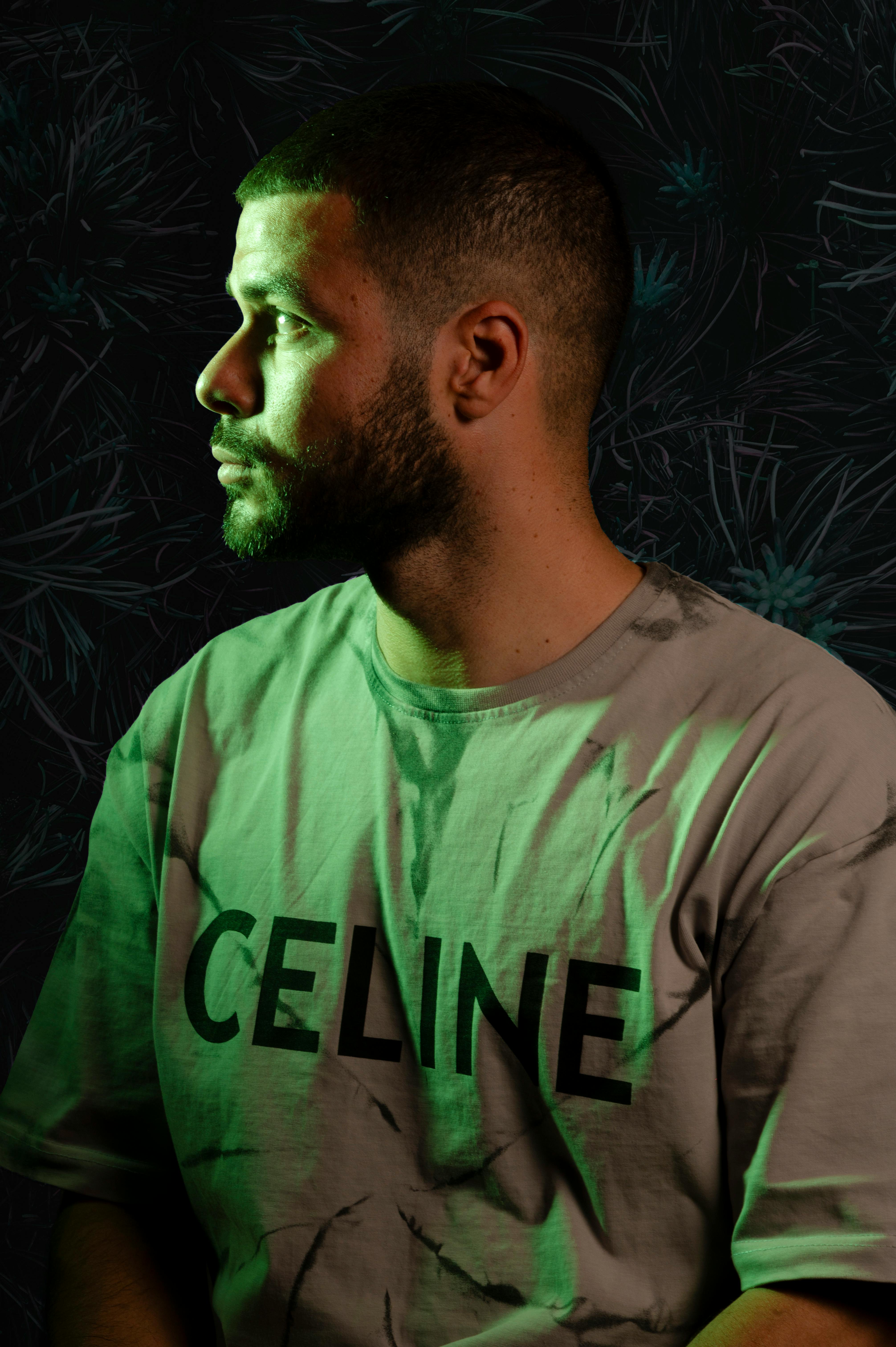 Artistic portrait featuring a man wearing a Celine t-shirt with dynamic lighting and a moody background.