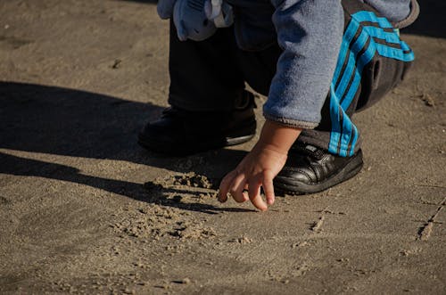 Boy Drawing in Sand 