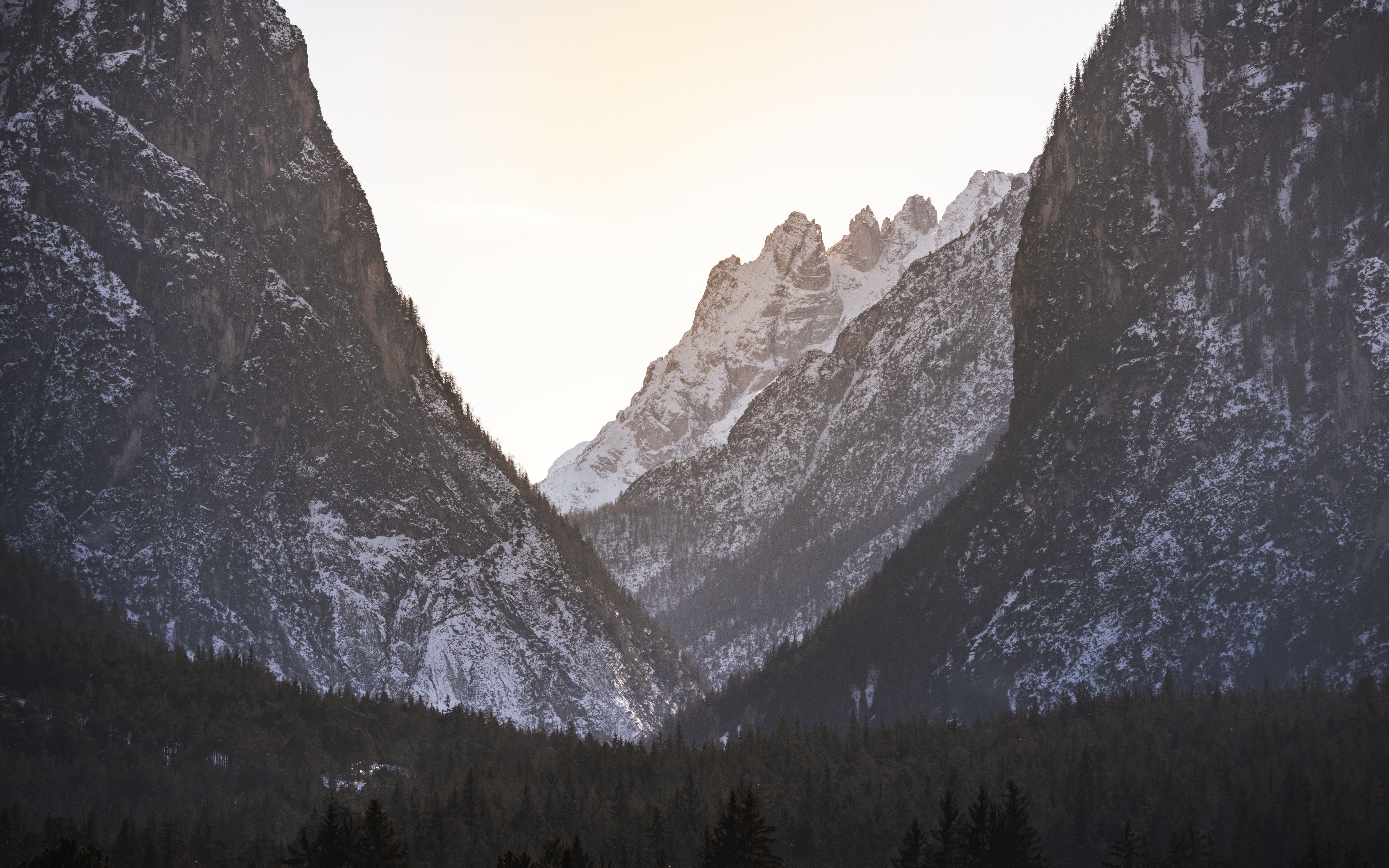 Breathtaking view of the snow-covered Dolomites as the sun sets, creating a magical atmosphere.