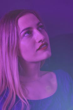 一幅女性向上凝视的艺术肖像，在柔和的紫色光线下，营造出梦幻般的氛围